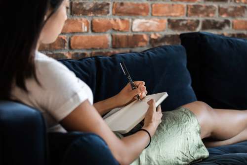 Woman Relazing And Journalling On Couch Photo