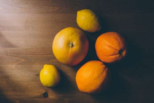 A grapefruit, oranges and lemons on a wooden table