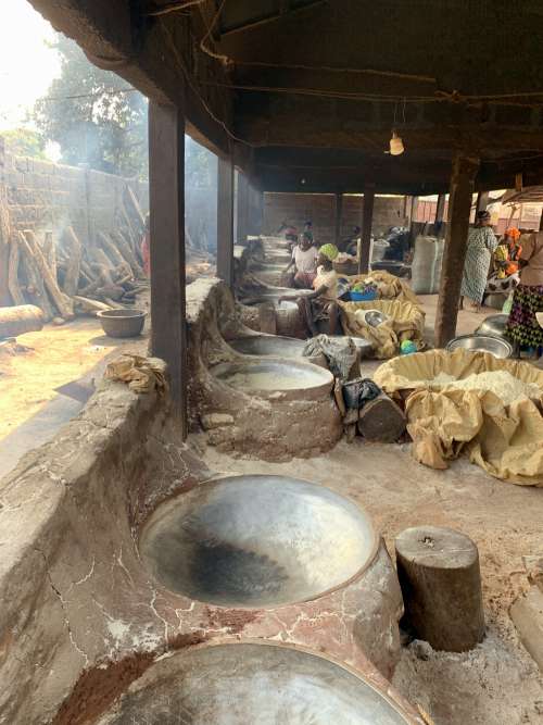 people, clay stove, pot, cylindrical wood, gari, cassava flour, local kitchen, cuisine, manioc production, local factory, rural, firewood, wooden ladle, work, women