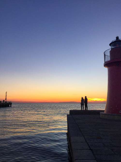 People Enjoy Blue Hour By The Water Photo