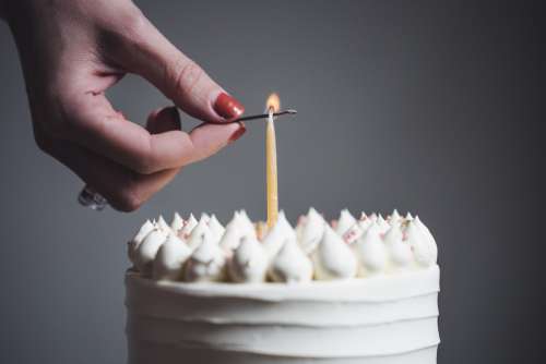 A Woman Lits A Single Birthday Candle Photo