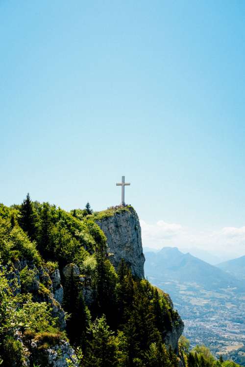Cross Stands Tall On A Cliffside Photo