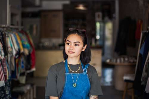 Woman Stands In Store With Apron On Photo