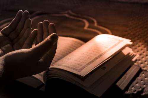 Hands In Prayer With Prayer Book Photo