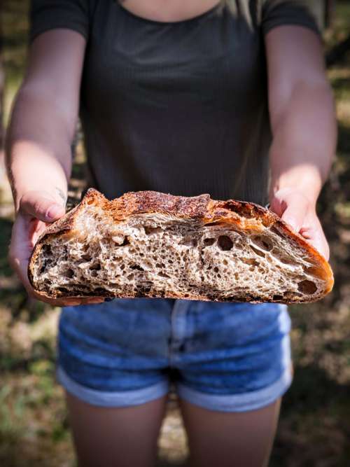 Girl holding delicious homemade sourdough bread