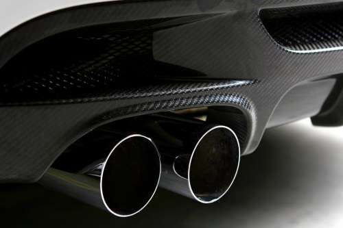 tailpipe of new white car on black background