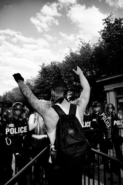 Protester facing police line, black and white