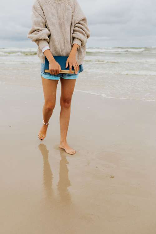 A young woman with a book on the seashore