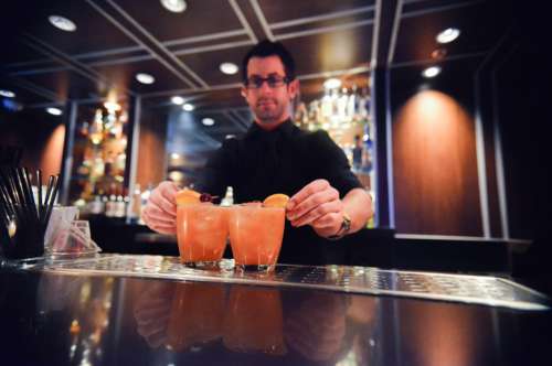 Man Serving Orange Coctails In Bar