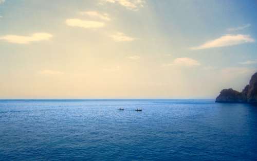 Two Boats Floating In Large Expanse Of Water