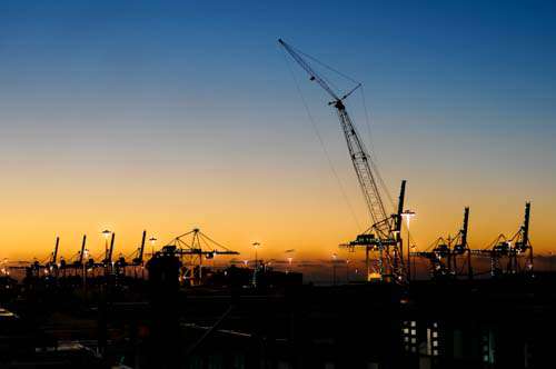 Sunset With Industrial Cranes In Silhouette