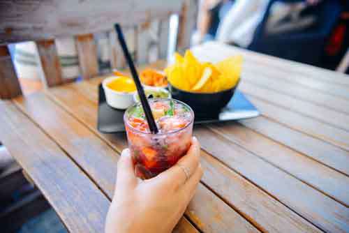 Woman’s Hand holding Cocktail With Fruit