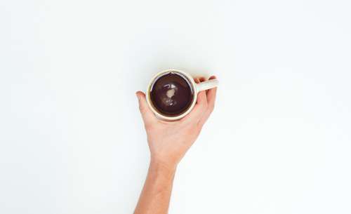 Mans Hand Holding Coffee Cup On White Background