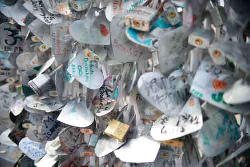 Lots Of Metal Hearts With Messages Attached To A Wall