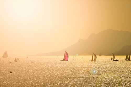 Many Sailing Boats At Sunset With Mountain