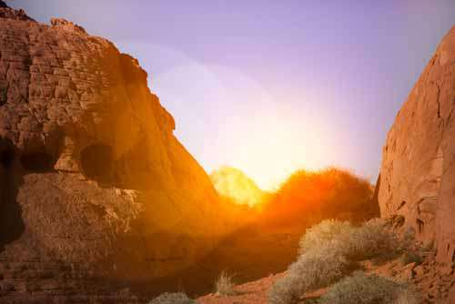 Sun Setting Behind Rocks In Desert
