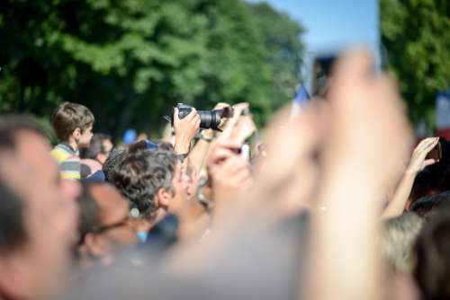 Man Taking Photo In Crowd Of People