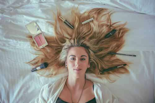 Cosmetics Make-up products Concept With Girl In Bed