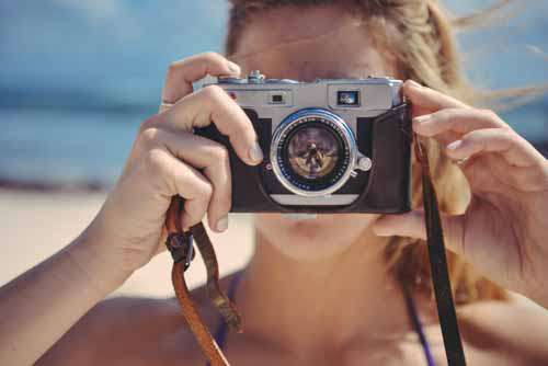 Blond Girl Taking Photo With Retro Camera In The Sun