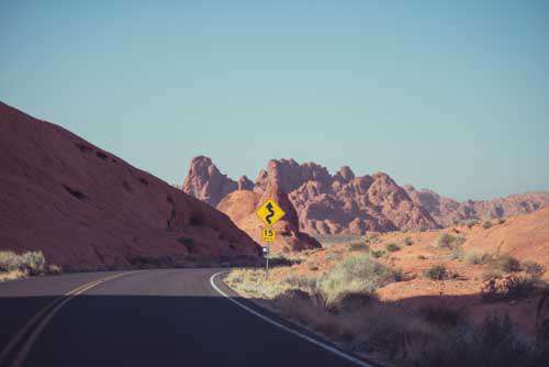 Empty Road Going Through Desert With Red Rocks