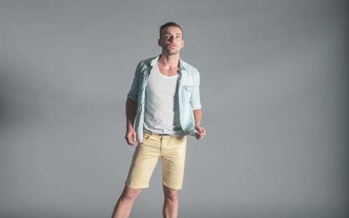 Stylish Man On Grey Background Wearing Summer Yellow Shorts And Shirt