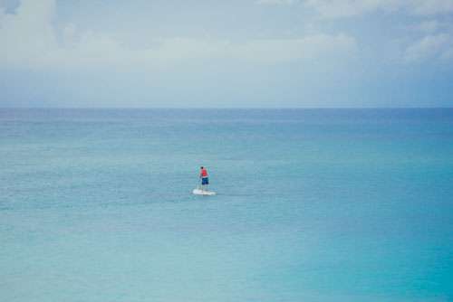 Man Paddle boarding In Perfect Blue Ocean