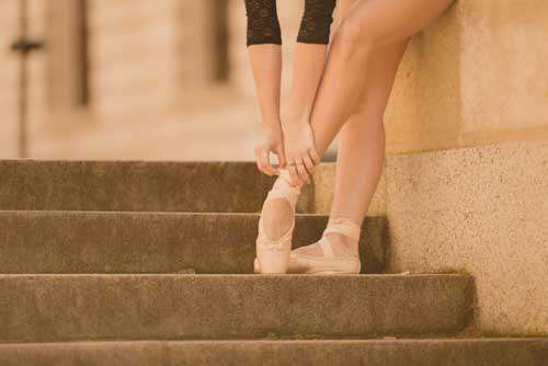 Girl Putting On Ballet Pointe Shoes For Dance