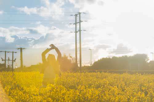 Girl Feeling Free In A Yellow Field At Sunset