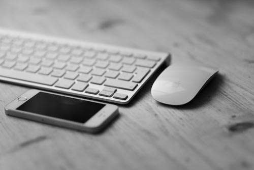 Keyboard, Mouse And Smartphone On Wooden Desk