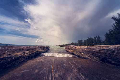 Coastal Landscape Of Boat Ramp, Rocks and Moody Sky