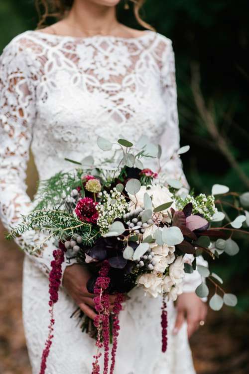 A Bride Holds Her Bouquet While Walking Down The Isle Photo