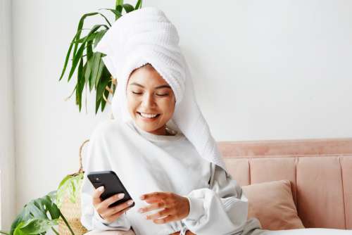 Young Woman With Hair Wrapped While On Her Phone Photo