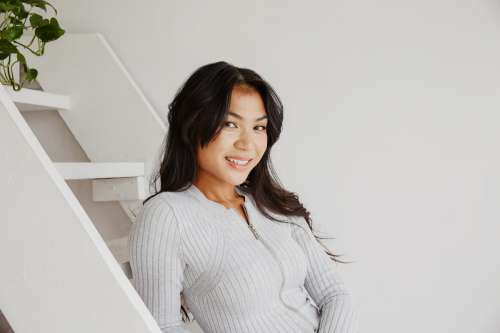 Young Woman Smiles While Posing On Steps Photo