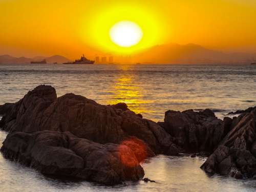 Sunset On Rocky Shoreline Photo