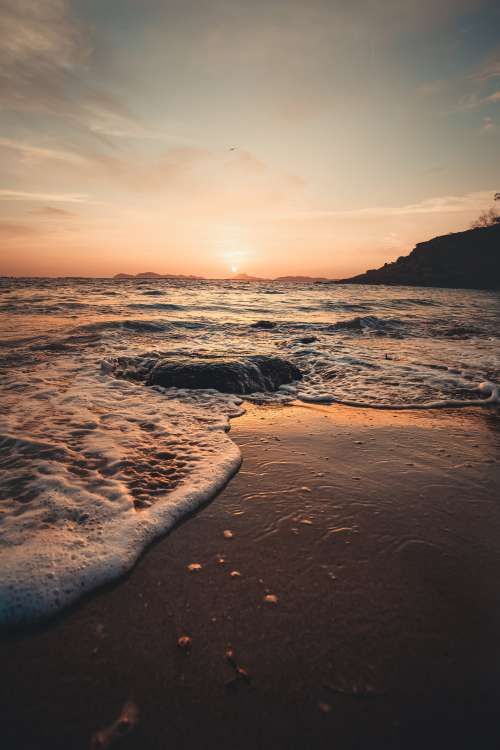Sunset Tide Spilling Onto Rocky Beach Photo