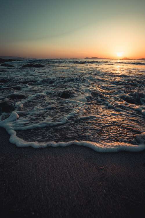 Picturesque Tide Rolling Below A Sunset Photo