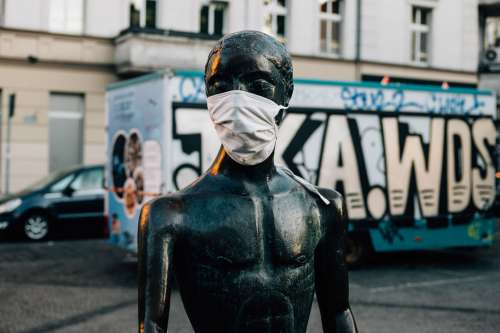 Street Scene Of Statue Wearing Mask Photo