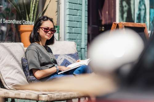 Young Woman Enjoying A Book In The Sun Photo