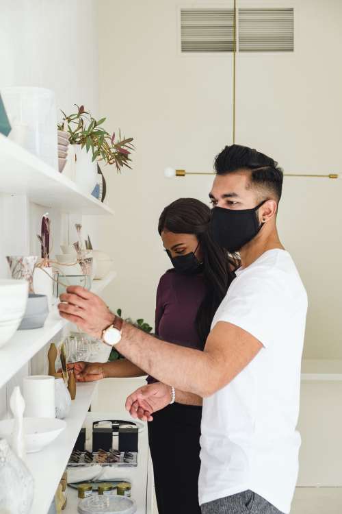 A Couple Shops While Wearing Face Masks Photo