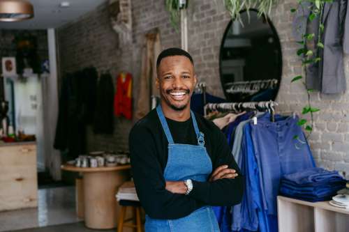 A Man In Denim Apron Smiles For The Camera Photo