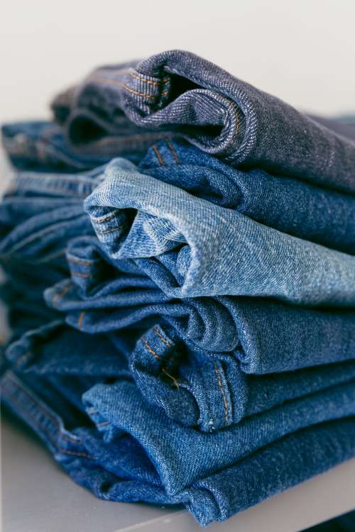 A Pile Of Denim Jeans In Different Shades Of Blue Photo