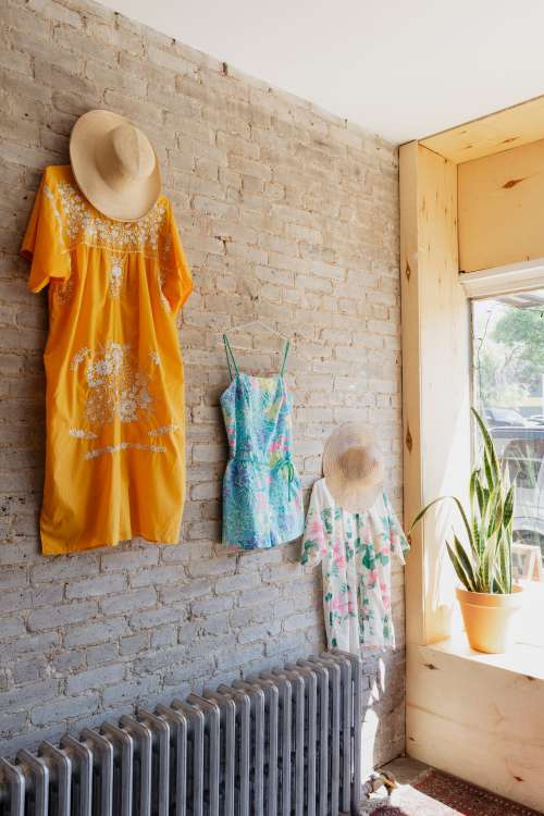 Summer Outfits Displayed On Exposed Wall In Store Photo