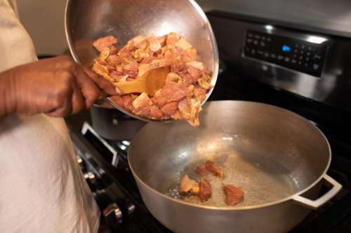 Meat pieces frying in cooking pot