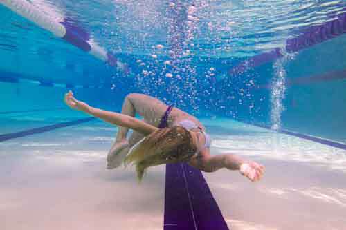 Girl Floating Underwater In Swimming Pool