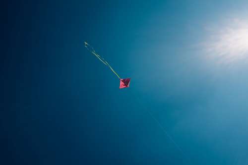 Minimalist Pink Kite Dots Through Blue Skies Photo