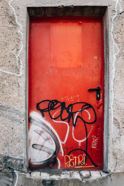 Big Red Graffitied Door In Concrete Wall Photo