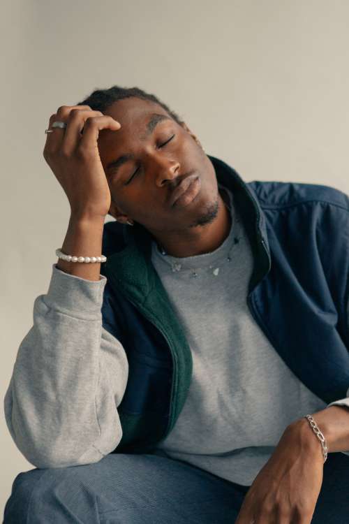 Young Man Holds Head With Closed Eyes Photo