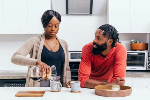 Couple Chat And Make Coffee In Their Kitchen Photo