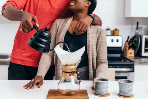 Couple Hug As They Pour A Cup Of Coffee Photo