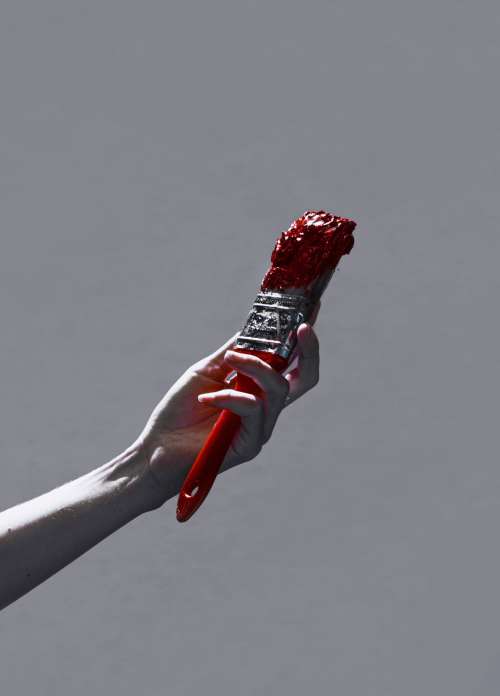 Hand Holding Up Red Paint Brush Photo